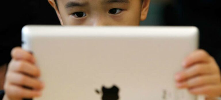 Un niño chino observa un iPad