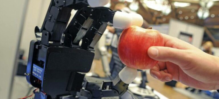 Un brazo robótico coge una manzana